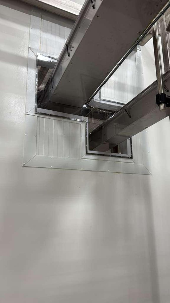 Sheet metal covers finished around conveyor penetrations through a plant wall